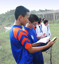 Students taking their GPS findings in a field.
