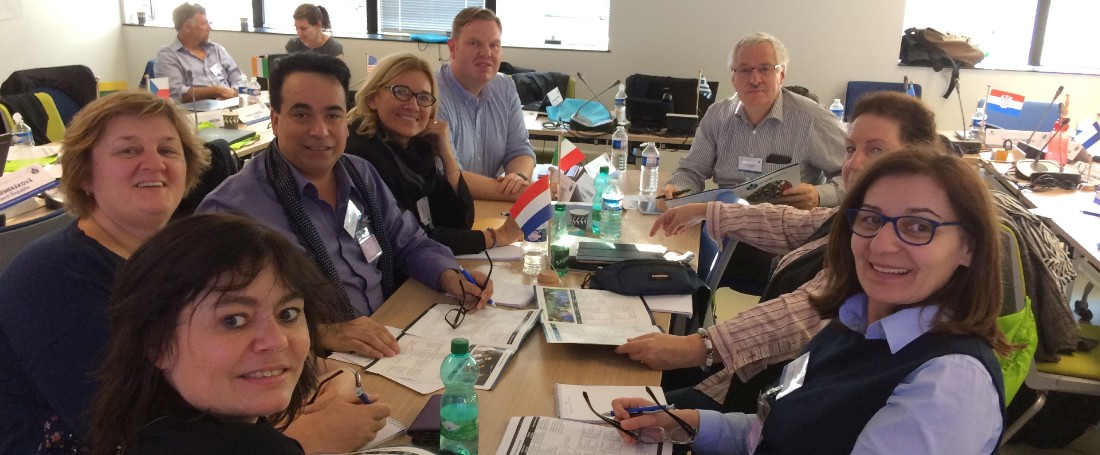 A group of GLOBE teachers being trained in a classroom, smiling at the camera.