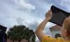 Two youth are taking a GLOBE Clouds observation using their tablets.