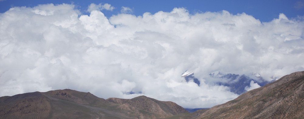 Landscape image of clouds over mountains.