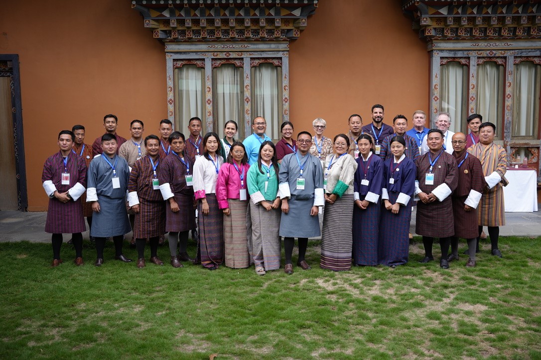 A large group of people pose together for a picture in front of a building.