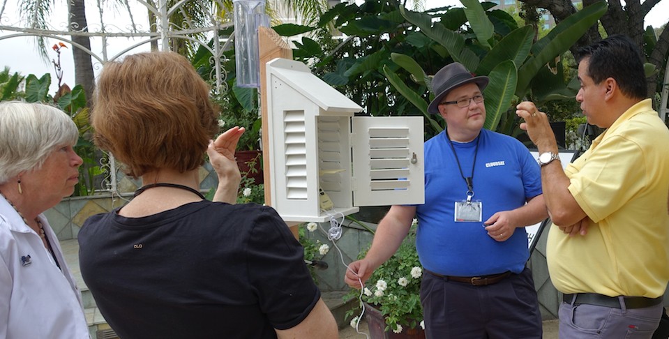 Four teachers talk around a scientific instrument outside.