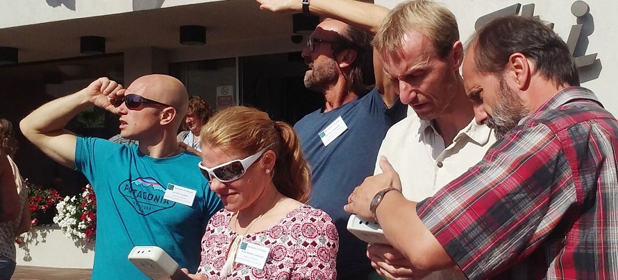 A group of teachers look up at the sky together.