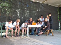 A group of GLOBE students gather around a teacher at a computer.