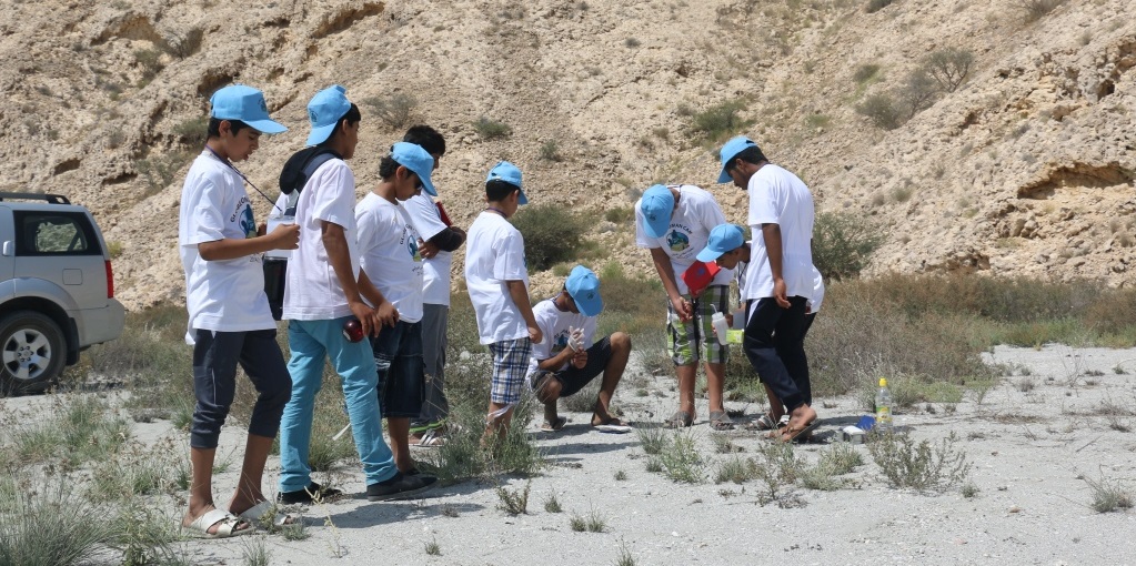 A group of students take measurements out of doors.