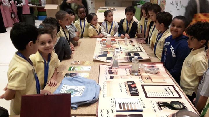 Several school children crowd around a short table.