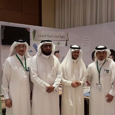 Four men in traditional Saudi Arabian dress pose for a photo.