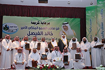 Several people stand and crouch together for a group photo showing their awards.