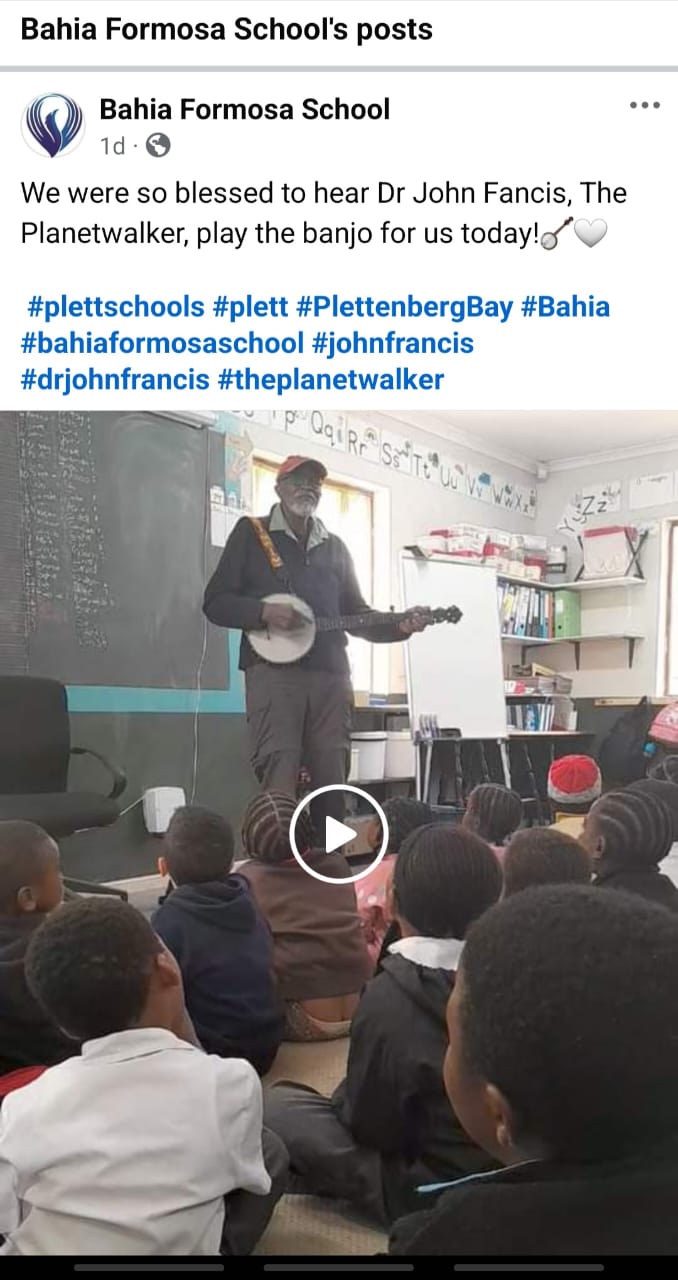 Dr. John Francis playing banjo in front of schoolchildren in Africa