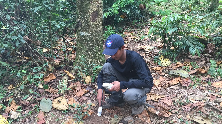 A boy takes a soil measurement.