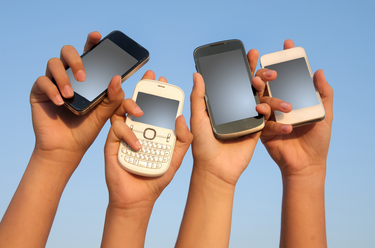 Photo of mobile phones in a group of hands in the air