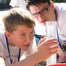 Two boy look together at a liquid sample.