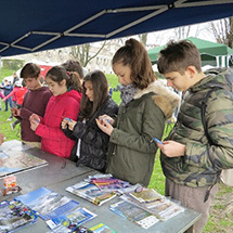 Students gather around a table looking at educational materials.