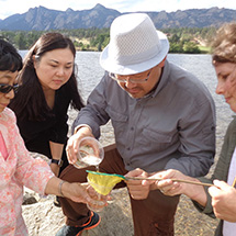 Four adults take a water sample.