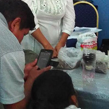 A man takes a photo with his phone while a woman looks on.