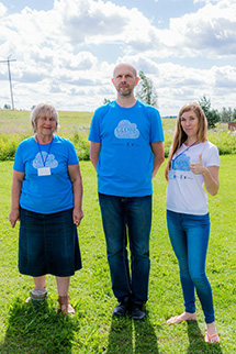 Three adults pose for photo.