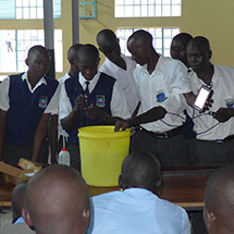 Students gather around a bucket.