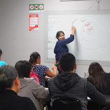 Claudia standing in front of the class talking about workshop evaluation.