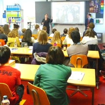 Mrs. Levine giving a presentation to students in a classroom.