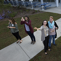 Several women use mobile devices out of doors.