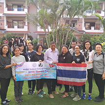 A group in front of a building holding a banner