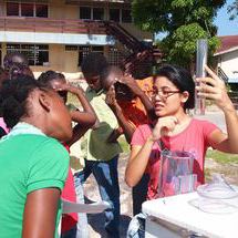 Several students veiw a scientific demonstration out of doors.