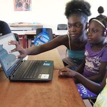 Estudiantes  sentadas frente a una computadora portátil.