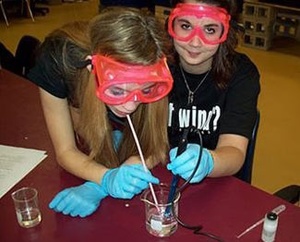 Students participating in an experiment on a table.
