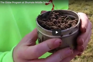 A pair of hands holding a pot of dirt.