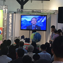 Dr. Tony Murphy is seen on screen while a crowd looks on.