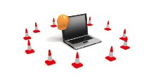 Site advisory showing caution cones and a hard hat near a laptop computer.