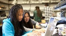 Students looking at a laptop.