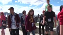 A group of students walk toward a camera.