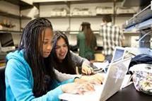 Students working on a computer together. 