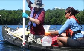 Photo of people on the water collecting water samples