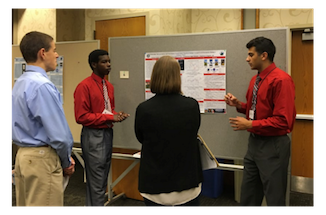 People discussing a science poster. 