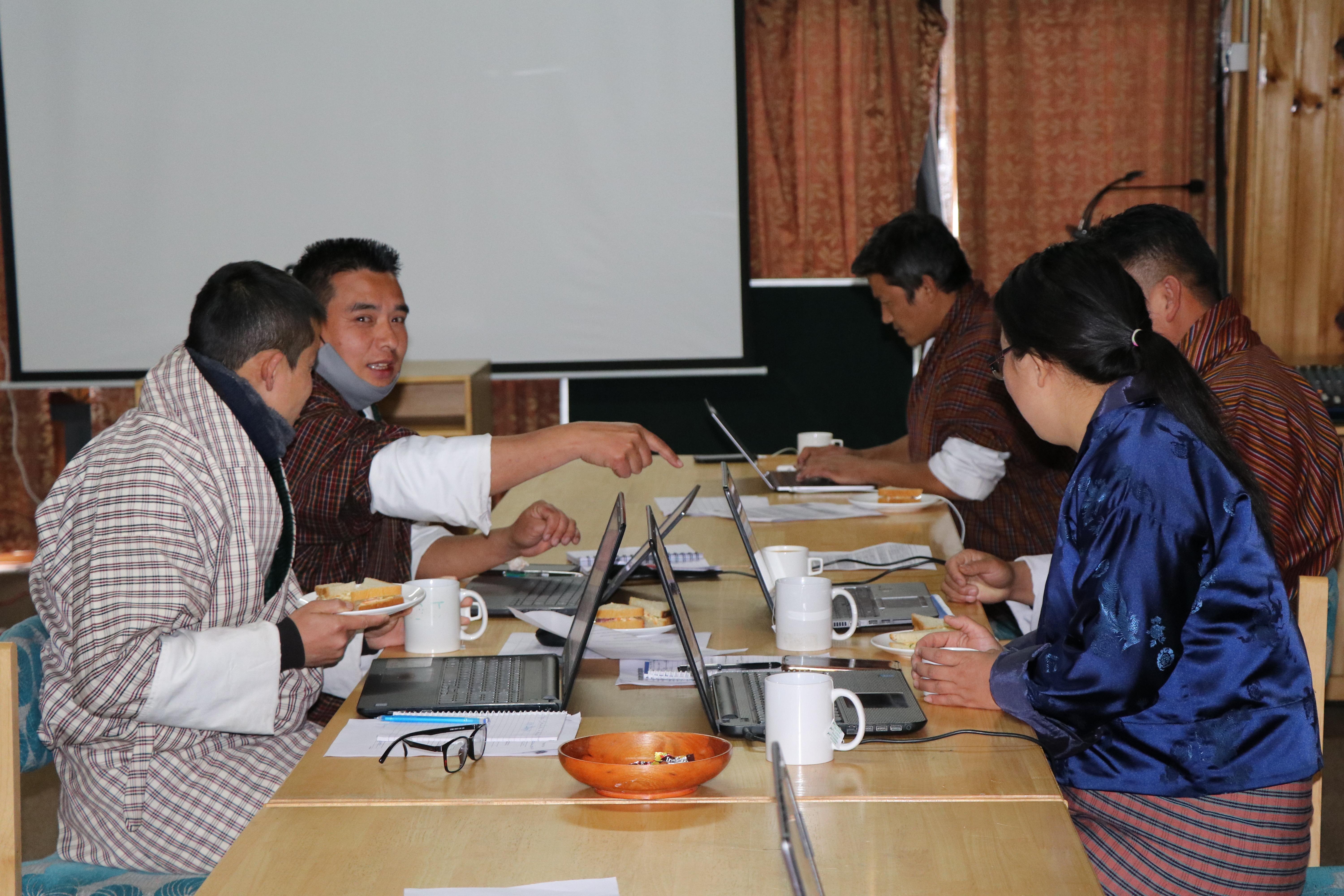 Group of teachers working on a student research project during a tea break