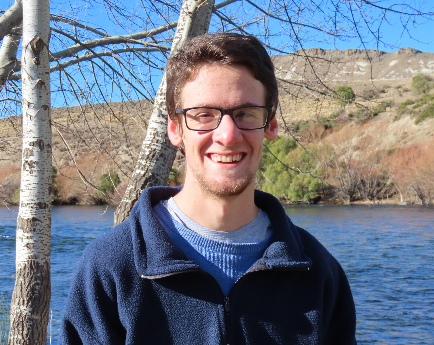 Photo of Juan, standing outside by a lake