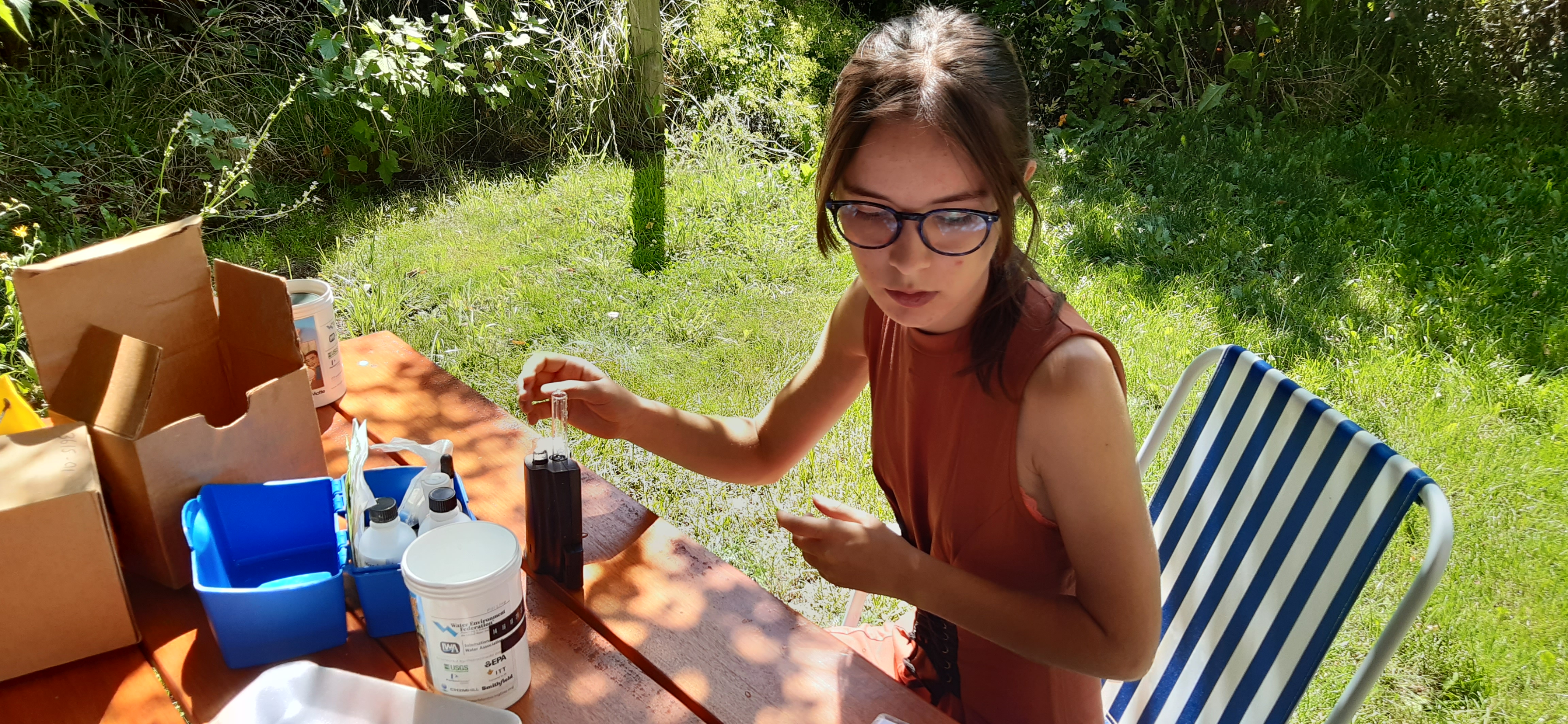 Photo of Marianela studying larvae at an outdoor table