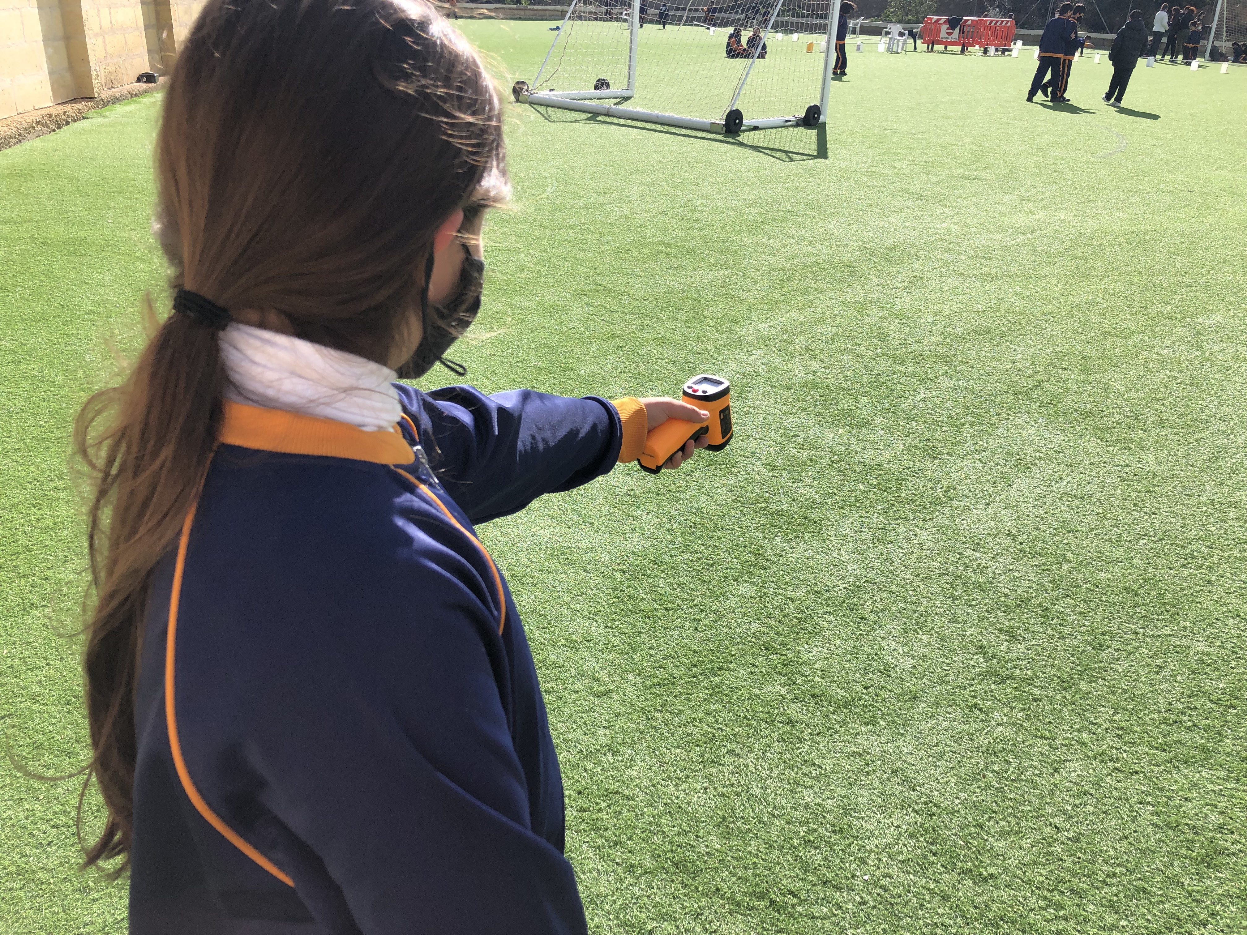 GLOBE student from Dingli Primary School measures surface temperature of artificial turf.