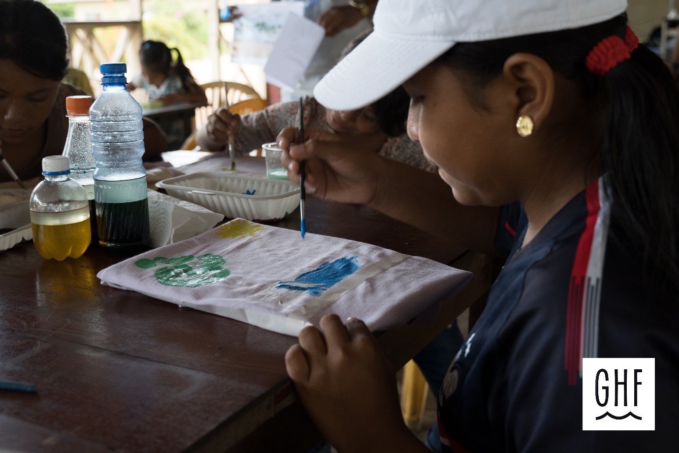 GLOBE Suriname student working on a summer vacation activity with water colors in the classroom