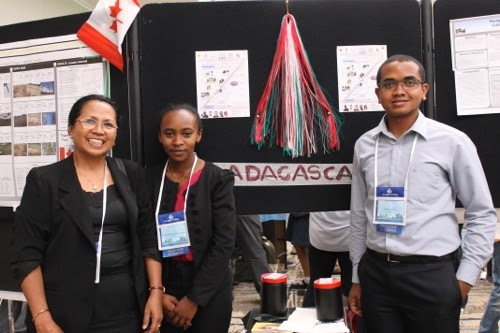 Three people stand near a science poster presentation.