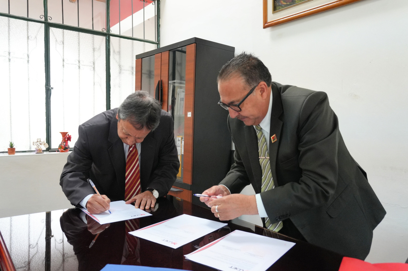 Two people signing papers