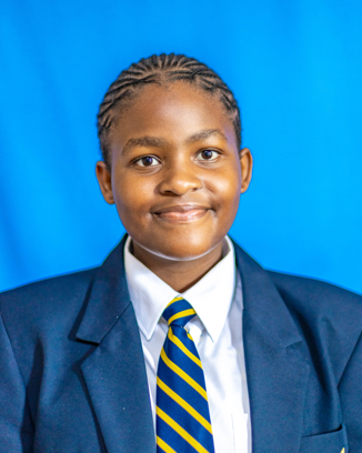 Student wearing school uniform and smiling.