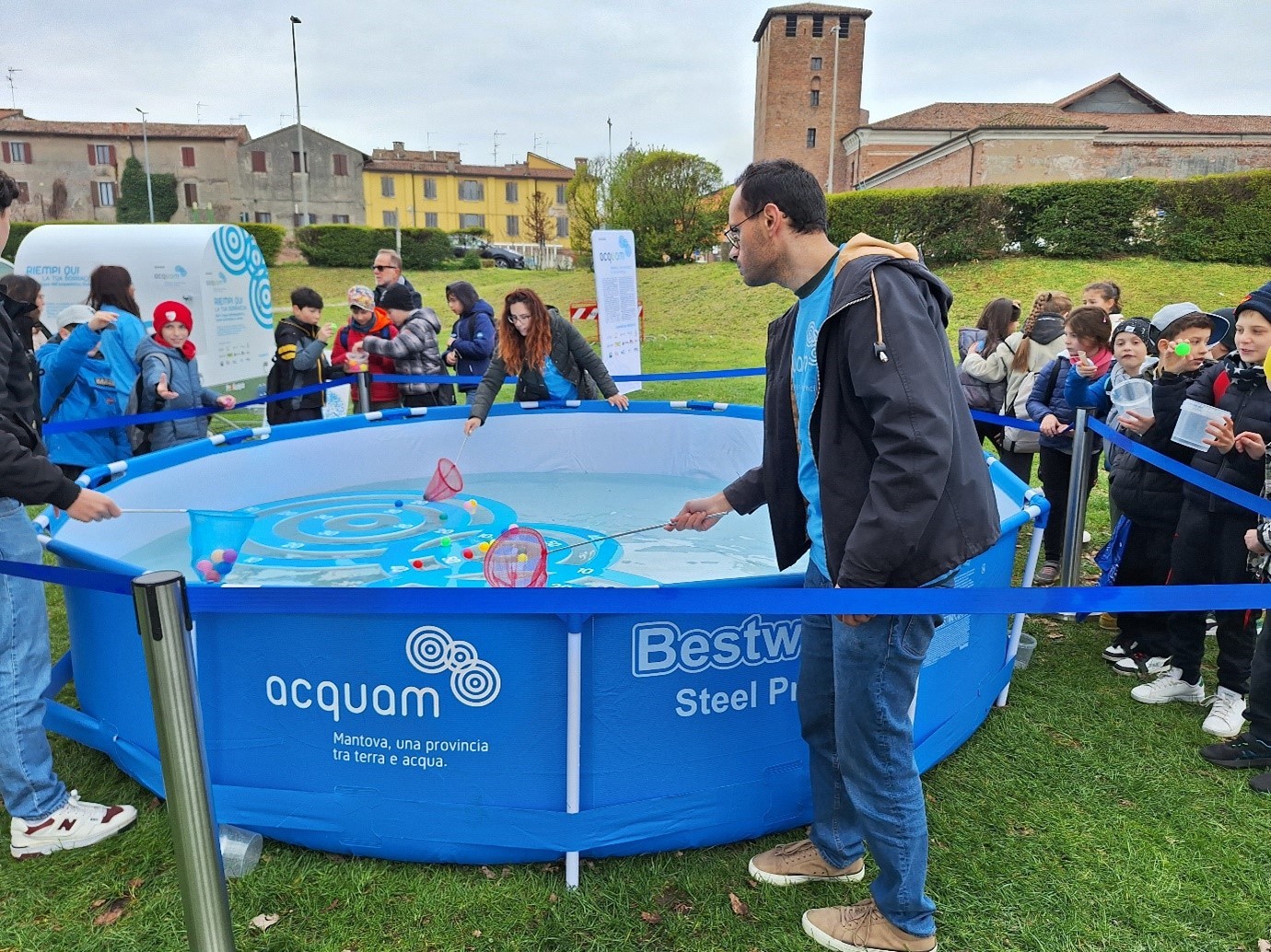 People playing a game using nets to scoop objects out of the water.