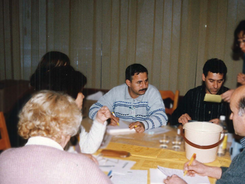 Group sitting and writing at a table.