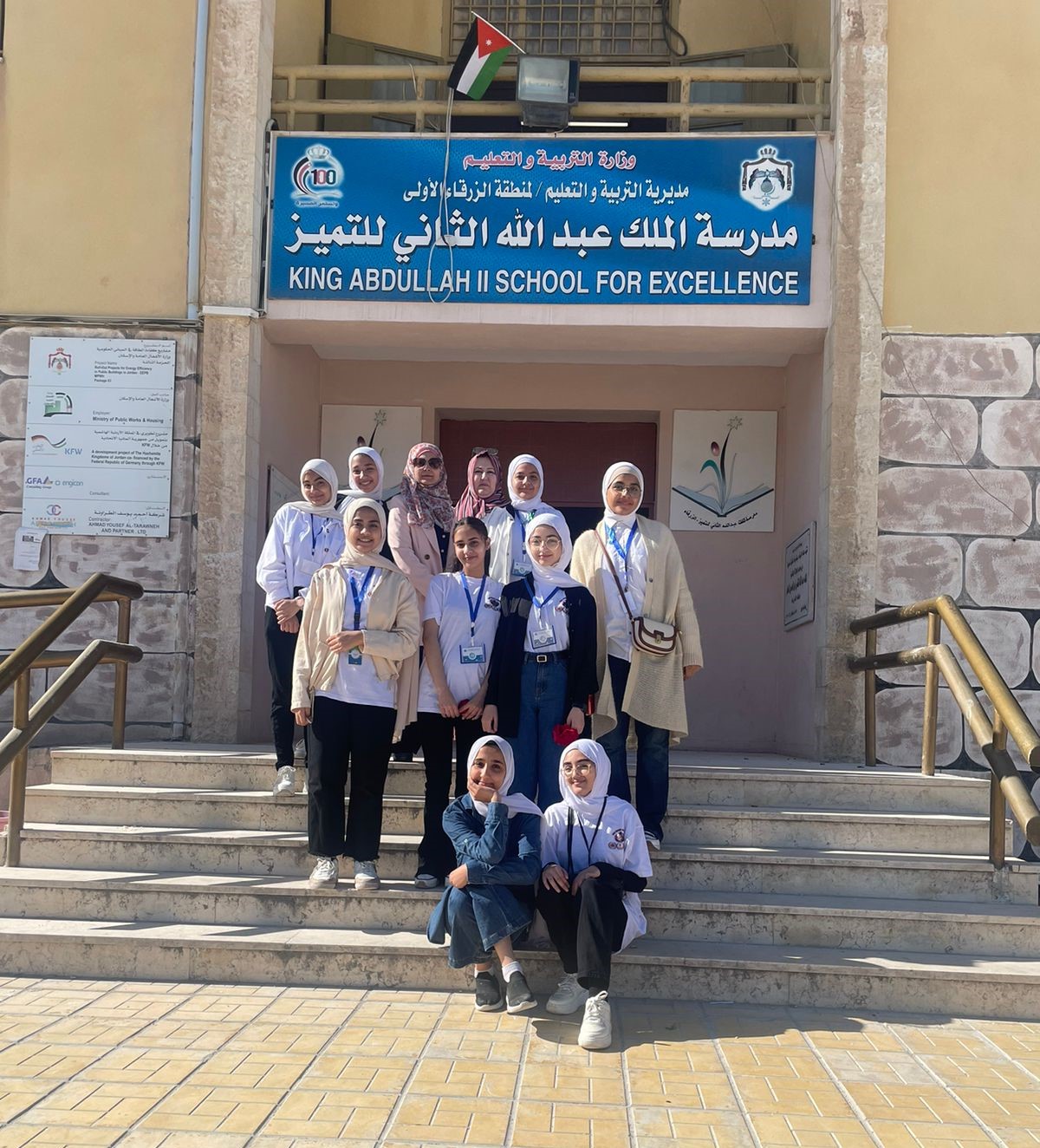 Group posing for photo on the steps of the school.