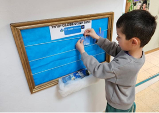 Child adding an image of a cloud to a board.