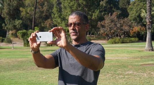 A GLOBE community member holding a phone to take photos