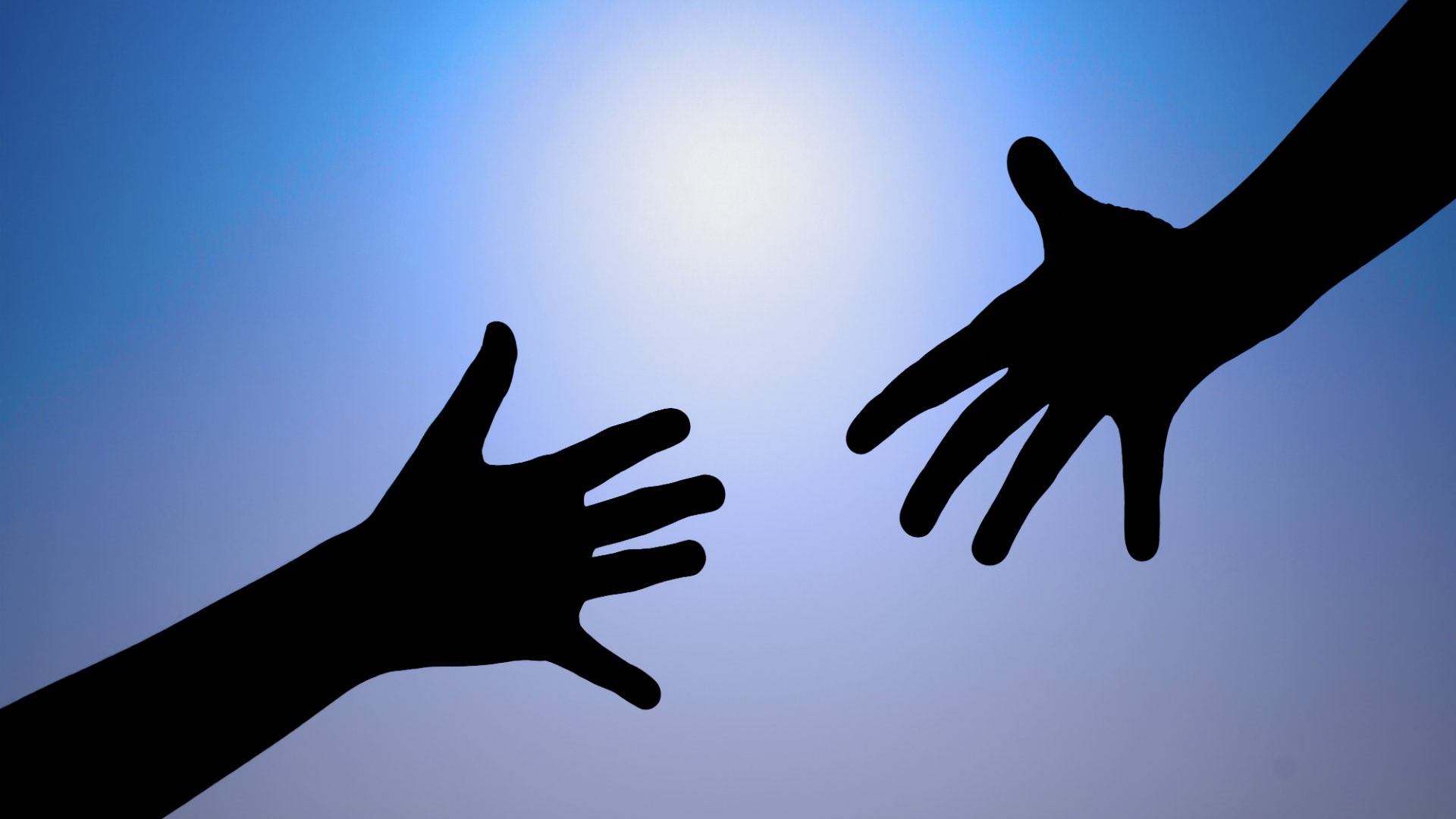 A photo of two hands; one reaching out for the other one